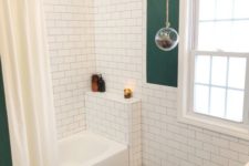 a small catchy bathroom with dark green walls and a ceiling, white subway tiles, black hex ones, a shower space and a window