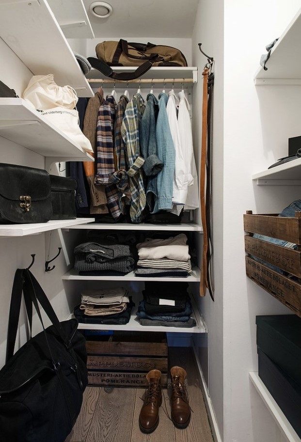 a small closet with wall-mounted and built-in shelves, a rack for hanging clothes, some crate drawers and boxes for shoes