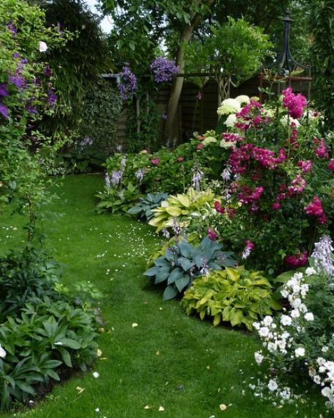 بالصور افكار بسيطة مميزة لتزيين حديقة المنزل حصري 2020 A-small-colorful-garden-with-a-grene-lawn-some-shrubs-bright-blooms-several-trees-in-the-corner