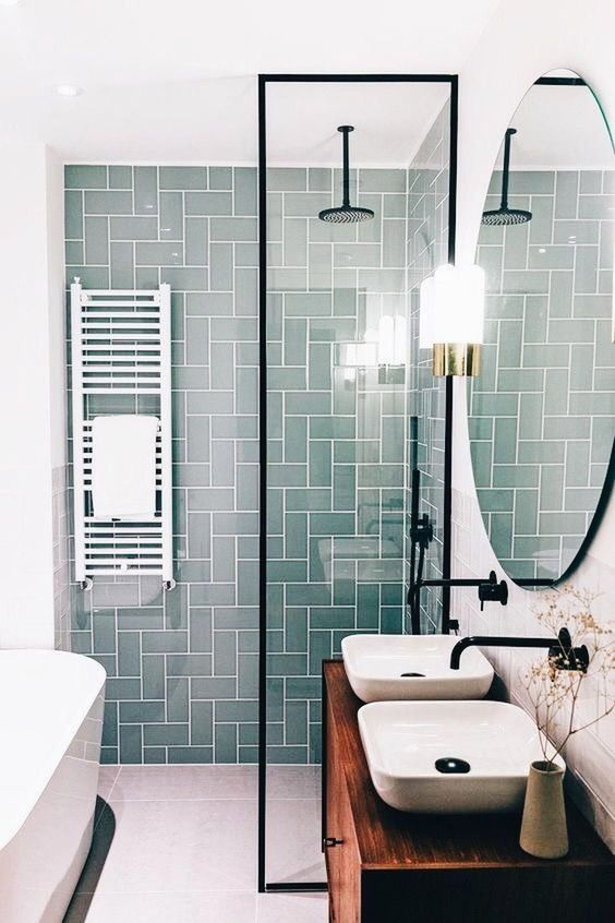 a small contemporary bathroom with a mint tile wall, a wooden vanity and touches of black for a modern feel