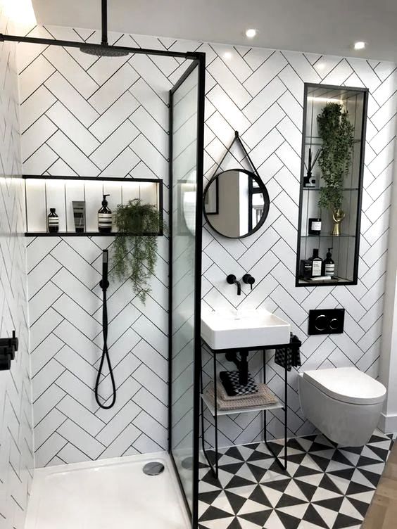 a small contemporary bathroom with herringbone clad tile walls, a printed floor, a small sink and a shower with a glass divider