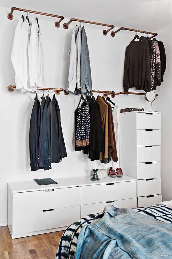 a small makeshift closet with rails with hangers and dressers will easily fit any bedroom and make most of your space