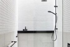 a small minimalist bathroom in black and white, with white small and large scale tiles, black fixtures and other touches
