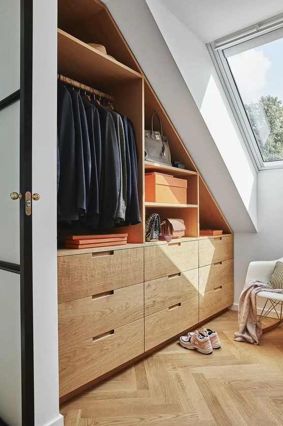 a small modern attic closet with open storage compartments and drawers and a chair is a comfortable and cool solution