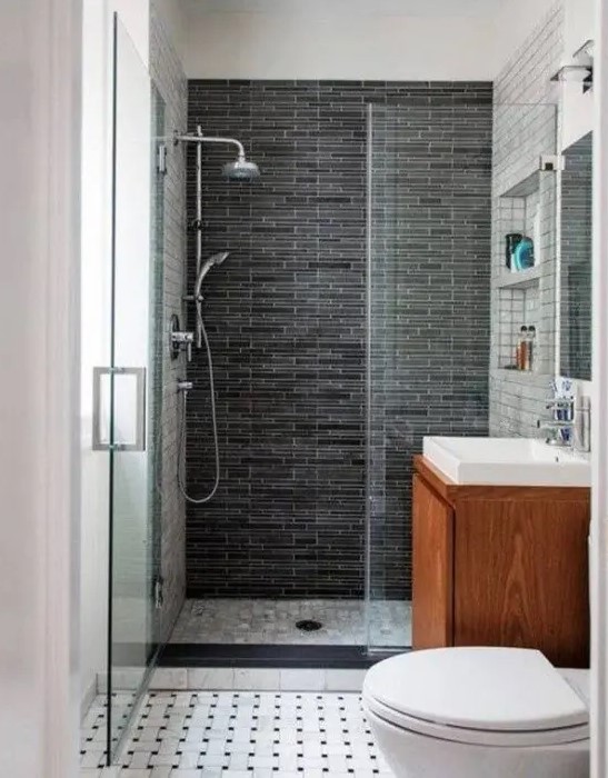 a small modern bathroom with a floating vanity, a shower space with a dark tile wall and a mosaic tile floor