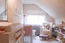 a small vintage-inspired attic nursery with a crystal chandelier, a large dresser, some furniture for the kid and adults