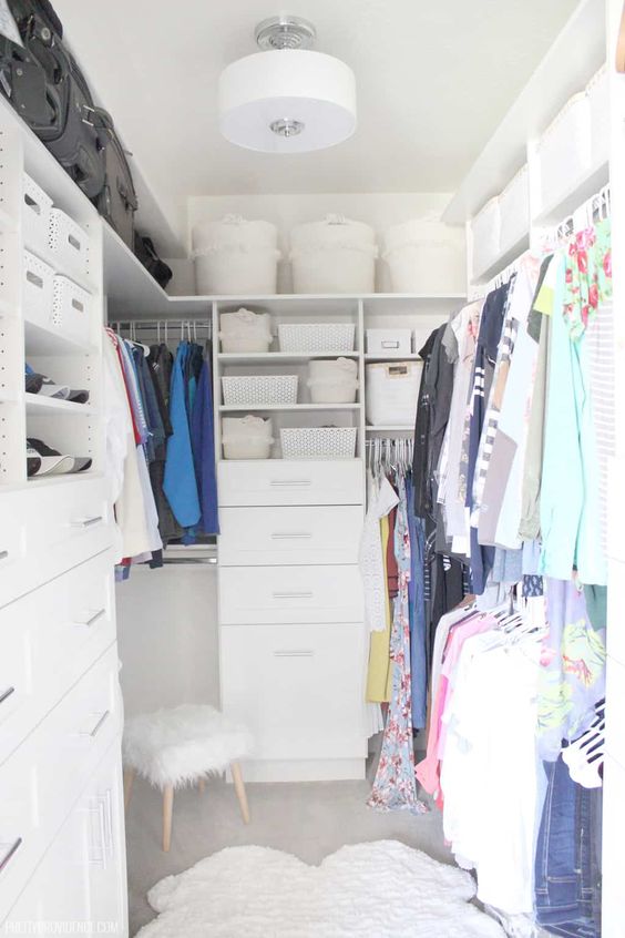 a small white closet with open shelves and baskets and boxes, built-in drawers and rails for clothes is a cool idea