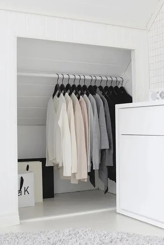 a smart and cool attic storage space turned into a closet with a holder for clothes hangers is a lovely idea