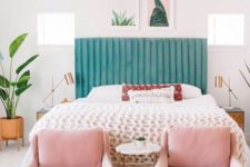 a stylish modern bedroom in neutrals spruced up with a green bed, pink chairs and a cool gallery wall that ties up these colors