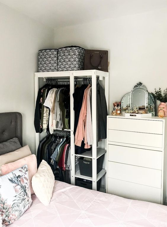 a tiny makeshift closet with rails, open shelves and a dresser next to it is a very smart and cool idea to rock