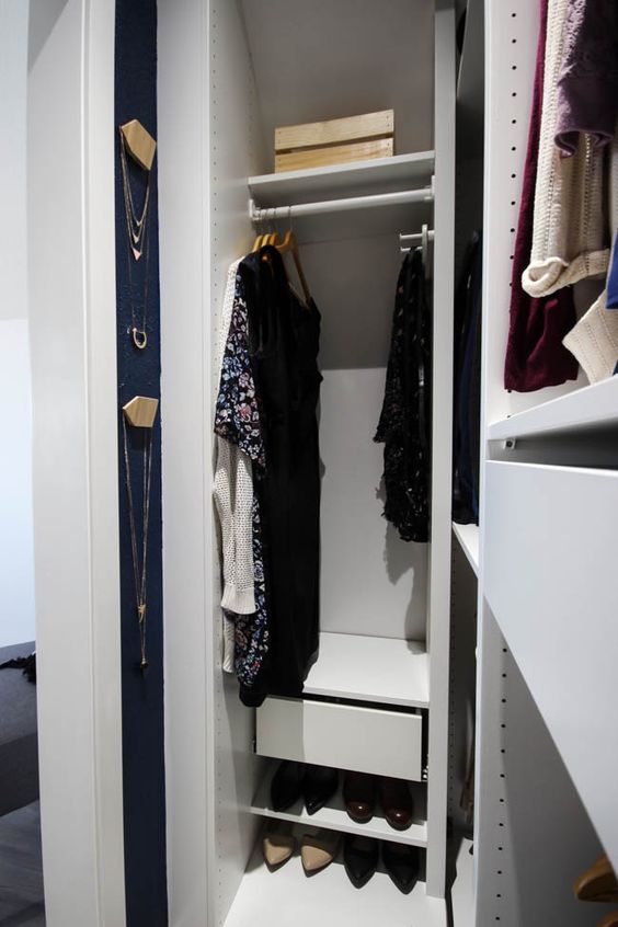a tiny minimal closet with open shelves, open storage compartments and some drawers plus wall organizers for jewelry
