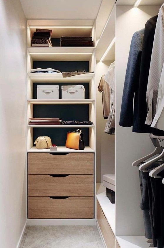 a tiny narrow closet with open lit up shelves, drawers and open storage units is a lovely space to be in