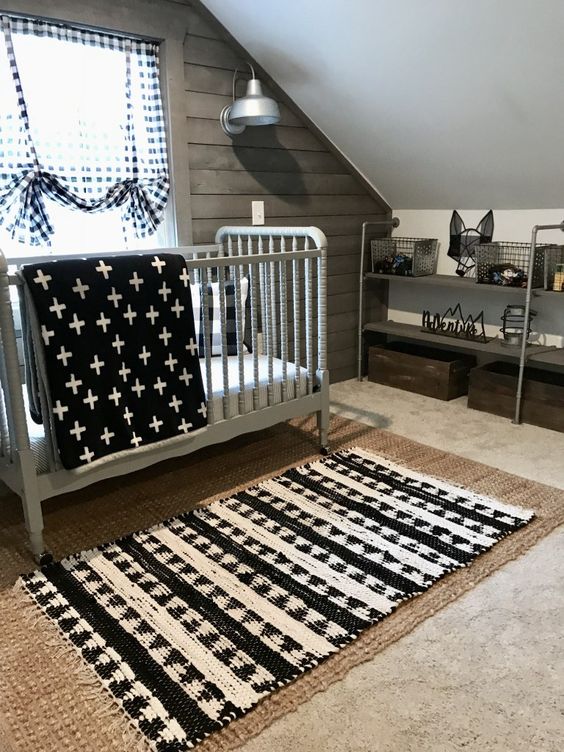 an attic boy's nursery in a monochromatic color schemme, with layered rugs, printed textiles and metal furniture