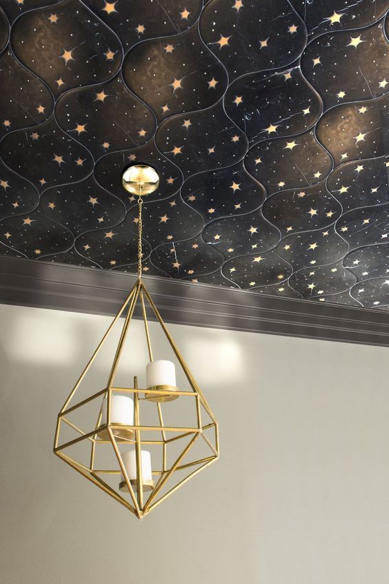 a beautiful black starry tile ceiling accented with a gold candle chandelier is a very bold and chic idea