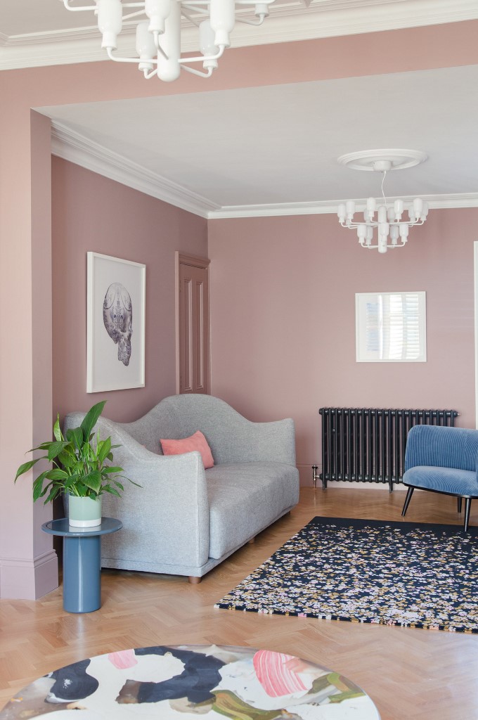 The furniture is curved, it's catchy and chic, there's potted greenery and a quirky chandelier
