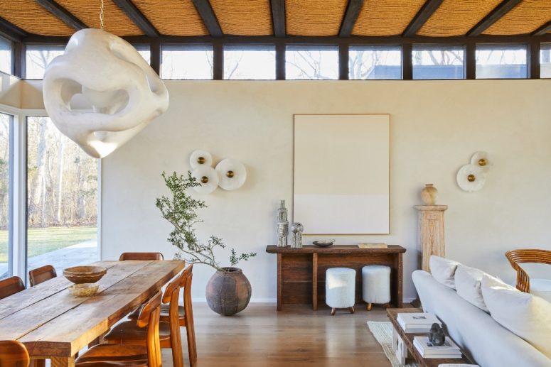 The living room and dining spaces are united in one, glazed walls and skylights fill the layout with natural light