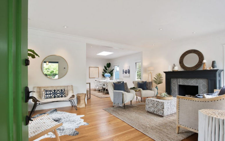 The living room is neutral, with chic mid-century modern furniture, a tile clad fireplace and several rugs