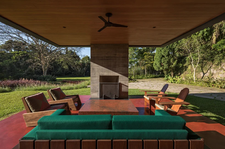 The terrace features a fireplace, a stone table, some comfortable furniture in modern style