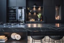 03 a black moody kitchen with plain cabinets and a stunning black marble kitchen island for a refined feel