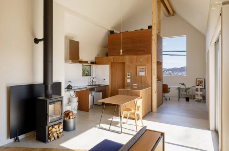 The kitchen is small, it's done with a couple of plywood cabinets, hanging bulbs, stone countertops and a small table