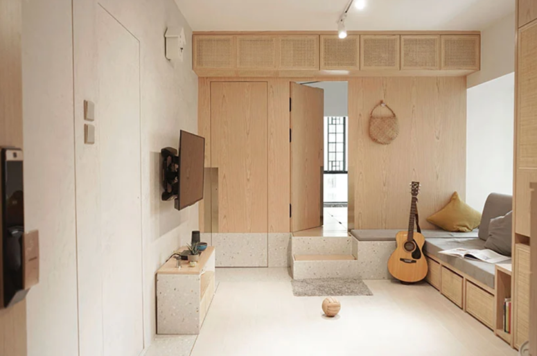 cool terrazzo touches makes the interior more interesting The living room is fully done with plywood, rattan and terrazzo, there's a platform that leads to the kid's room and it doubles as a seating