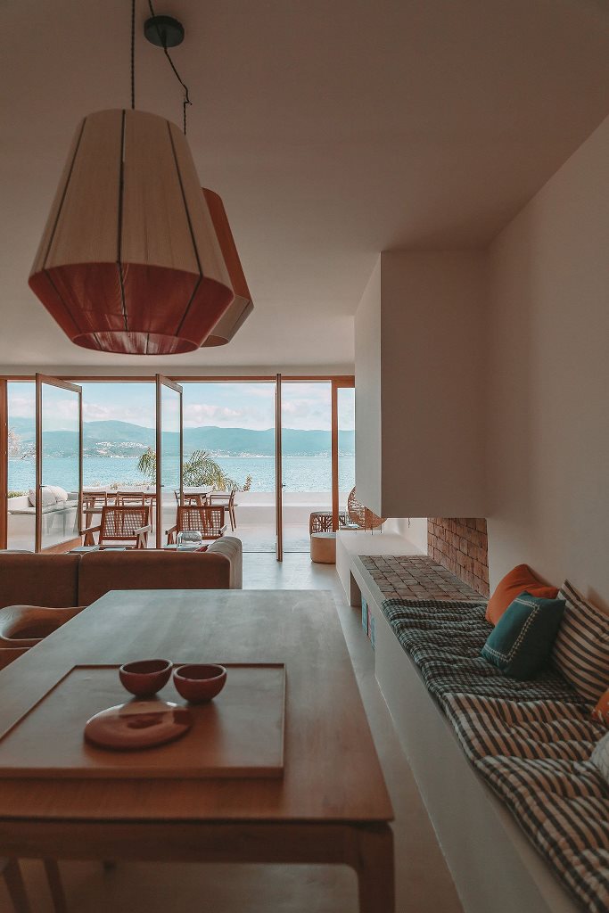 The living room with pendant lamps, an open fireplace, chic furniture and it's fully opened to outdoors The living room with pendant lamps, an open fireplace, chic furniture and it's fully opened to outdoors