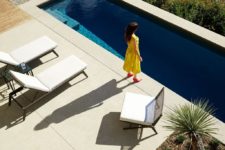 04 There’s a long and narrow pool and white loungers and chairs by its side