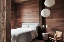04 This bedroom is fully clad with wood, there’s a comfy bed, some paper lamps and a leather chair