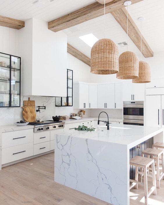 a chic white kitchen with white marble countertops and a backsplash plus a marble kitchen island for a refined feel
