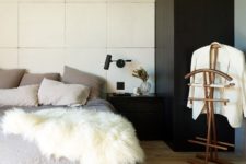06 The bedroom shows off a contrasting color schemes, a luxurious bed and sconces