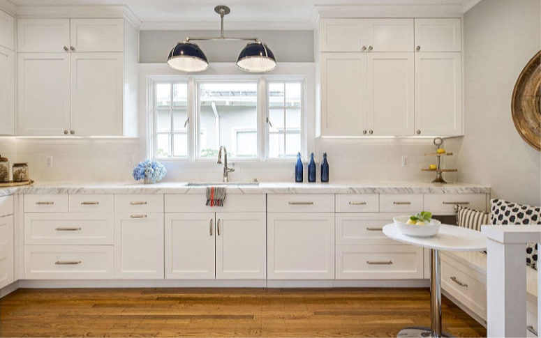 kitchen with a cool stone countertop The kitchen is white, with a stone countertop and a small and cozy breakfast nook with a built-in seat