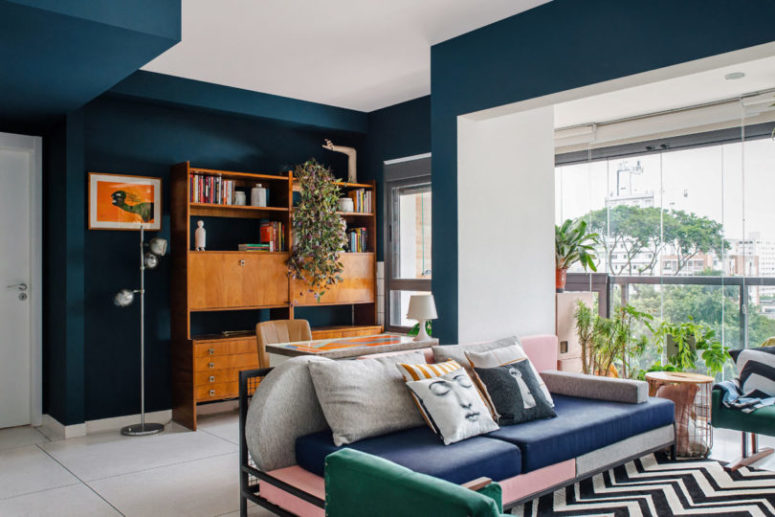 The living room shows off another cool mix of colors and prints and a glass wall to fill it with natural light