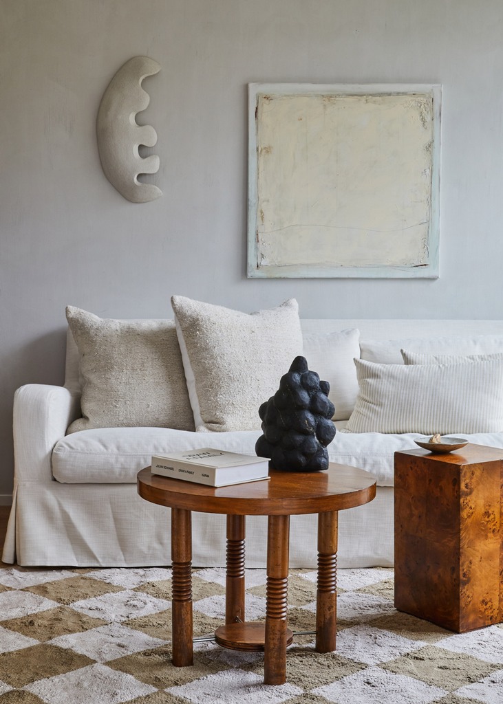 The living room is done with a white sofa, a wooden table and some simple pillows