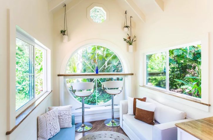 The living room is done with a gorgeous round window, a bar space and two small sofas