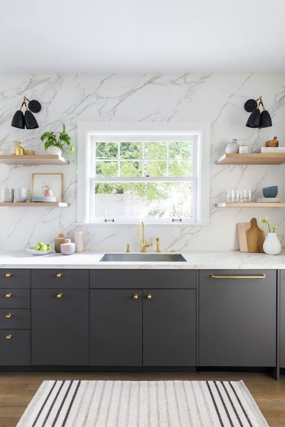 a graphite grey kitchen with a white marble wall and countertops plus touches of gold for more chic