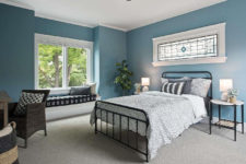 09 A guest bedroom is done in blue, with several windows, comfy metal and wicker furniture and monochromatic textiles