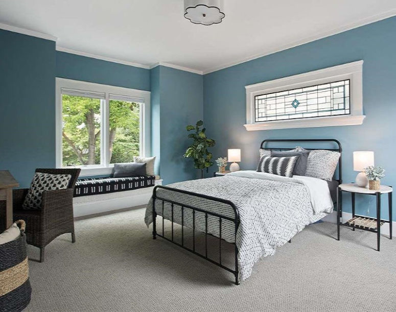 A guest bedroom is done in blue, with several windows, comfy metal and wicker furniture and monochromatic textiles A guest bedroom is done in blue, with several windows, comfy metal and wicker furniture and monochromatic textiles