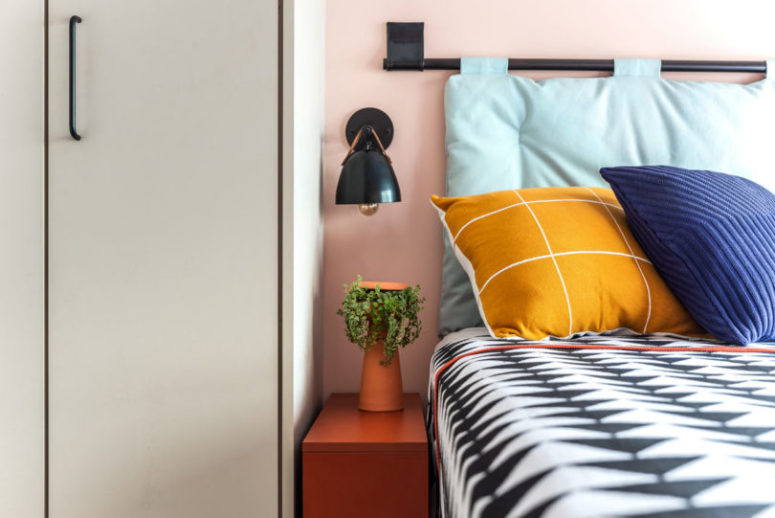 The bedroom also shows off bright colors and prints and matte black touches add drama here
