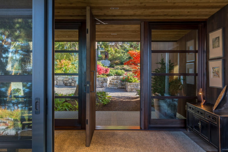 The entryway is fully glazed, with a dark vintage sideboard for storage