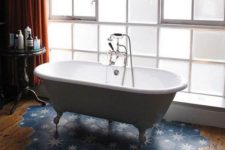09 a stylish bathroom with a wooden floor and a blue hex tile with stars floor piece under the tub is gorgeous