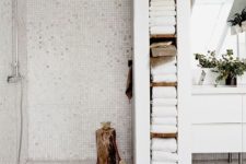17 a built-in shelving unit that doubles as a shower space divider and holds all the towels is a smart solution