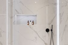 20 a minimalist white bathroom fully clad with marble, with a tub and a shower plus built-in lights for a refined feel