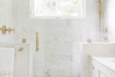 21 a glam bathroom clad with white marble tiles completely, with large scale tiles on the walls and herringbone ones on the floor