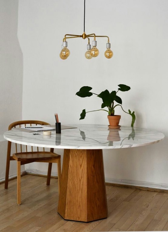 an elegant mid-century dining table with a wooden faceted base and a white marble tabletop