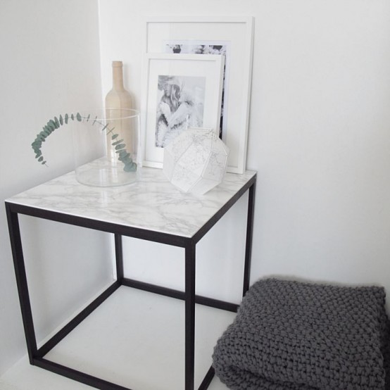 a side table with a black metal base and a white marble countertop - if you can't afford marble, go for contact paper