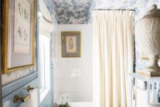 a beautiful vintage-inspired blue and white bathroom with a printed wallpaper ceiling echoing the colors below
