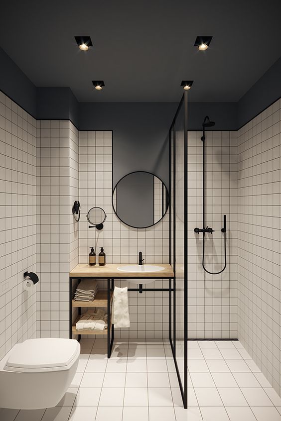 a grey and white bathroom accented with black edges, fixtures and mirror frames looks more modern and bolder