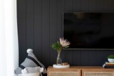 a neutral living room with a black beadboard wall for a bold and contrasting statement in the interior