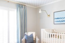 a rather neutral blue and white kid’s room made cooler with a printed wallpaper ceiling that adds catchiness to the room