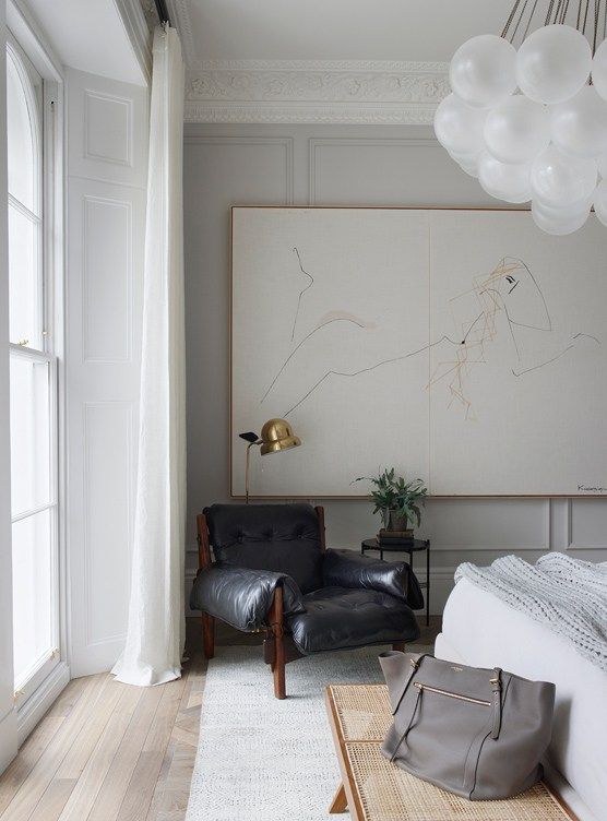 a single black leather chair will make a super bold statement in a chic neutral bedroom like this one